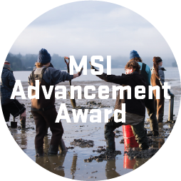 Photo of two students on mudflats high-fiving with a text overlay that says "MSI advancement award"